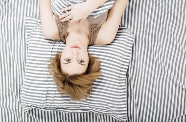 Kız yatakta kahve içiyor. Günaydın kızım. Genç kız sabah uyanır. Uyu. Sabah uyanışı. Yatakta basın okuyor. Battaniyenin altında.