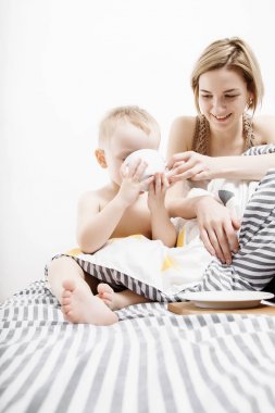 Anne küçük oğlu olan sabah uyanıyorum. Sabah uyanma anne ve bebek. Kucaklama.