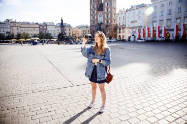 Krakow için seyahat. Kız gitti ve şehir ve onun sokakları fotoğraflar. Krakow, Polonya Avrupa bir şehirdir. Belgili tanımlık çarşı ortasında ve eski şehrin genç bir Bayan.