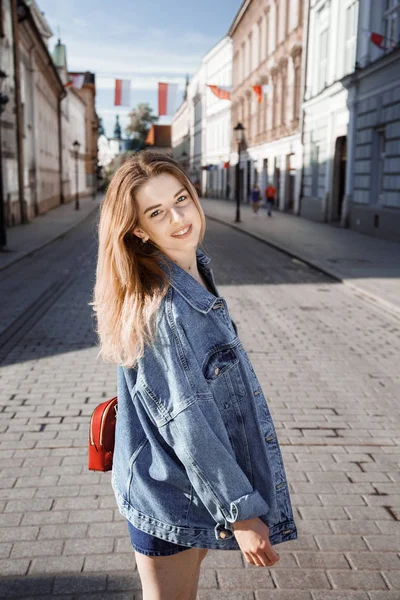 Viaje para Cracóvia. A menina viaja e fotografa a cidade e suas ruas. Cracóvia é uma cidade europeia na Polónia. Uma jovem no meio do mercado e na cidade velha . — Fotografia de Stock