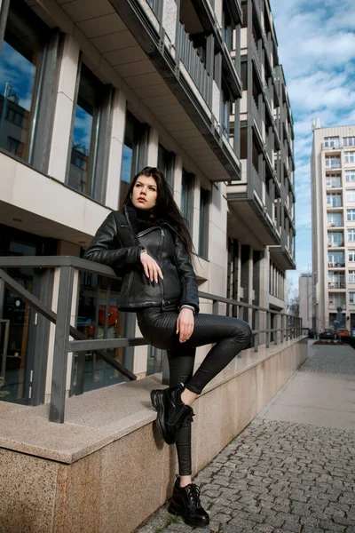 Young woman in the city. Beautiful girl on the street in Warsaw. Girl in black. Brunette on the streets of the capital of Poland.