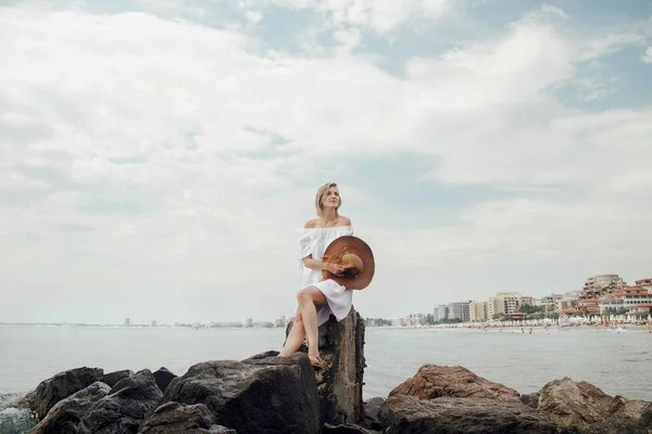 Una joven junto al mar. Hermosa chica en vestido blanco y sombrero de vacaciones. Viaje al Mar Negro . — Foto de Stock