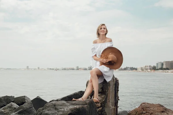 Una joven junto al mar. Hermosa chica en vestido blanco y sombrero de vacaciones. Viaje al Mar Negro . — Foto de Stock