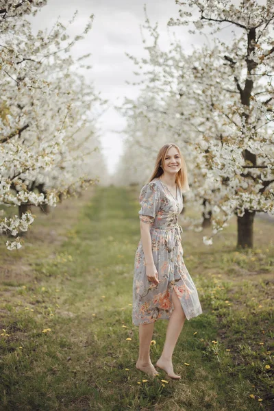 Çiçek açan bahçede güzel bir kız. Kiraz bahçesi. Sring Kavramları. Pozitif 'in yakın plan portresi. Çiçekli bir bahar bahçesinde kokan mutlu genç bir kadın..