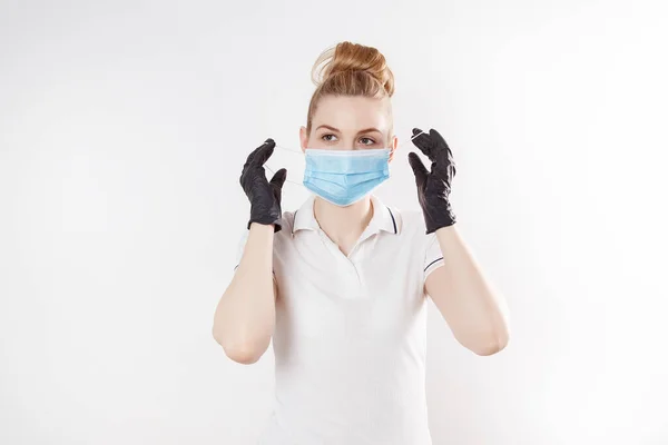 Girl in a medical mask and rubber gloves. Means of protection in quarantine. Mask and gloves.