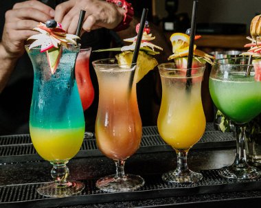 Kokteyller barda. Bar masasında alkollü kokteyl sıraları, renkli parti içkileri..