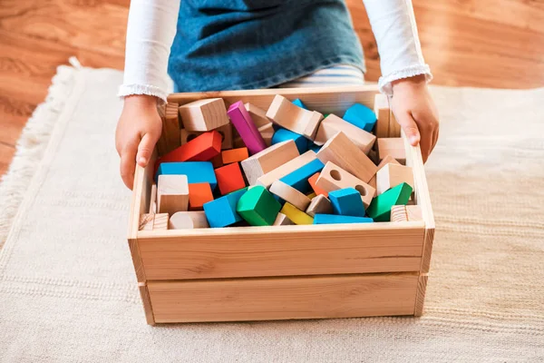 Little girl cleaning up the toy box at home. Stock Photo