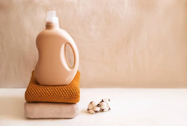 Bottle of detergent on a pile of sweaters.