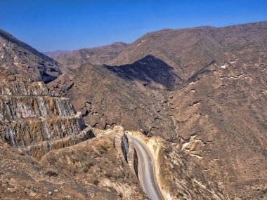 Yamaçtan geçen virajlı bir yol Güney Umman 'daki derin bir kanyona çıkar.