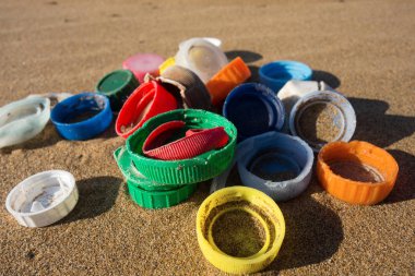 Plastic plugs collected on the beach. Ocean plastic pollution concept. clipart