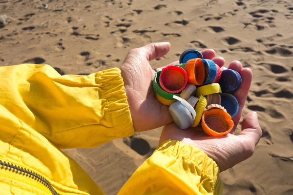 手中塞满了收集在海滩上的塑料塞子 海洋塑料污染概念 — 图库照片