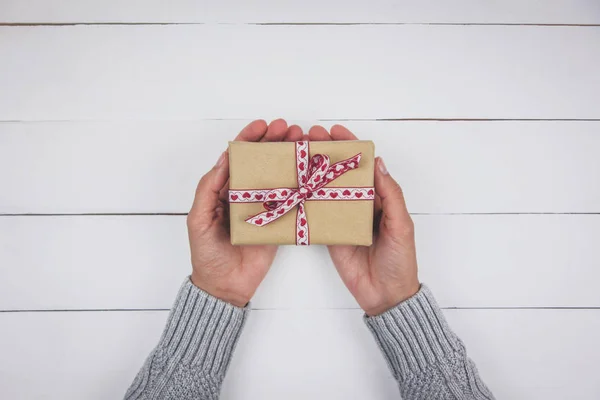 Mano Donna Con Maglione Grigio Che Tiene Regalo Con Fiocco — Foto Stock