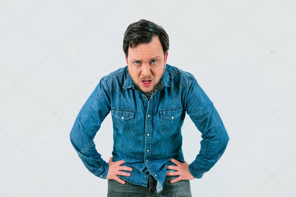 Young man with expression of tiredness and exhaustion. Denim shirt and isolated white background.
