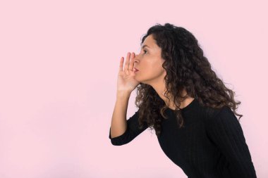 Kıvırcık saçlı esmer kadının bir sırrı, dedikoduyu ya da terfiyi anlattığının profili. Siyahlar içinde dikilirken.