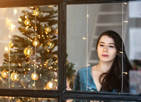 クリスマスツリーを背景に美しい若い女性。ホームパーティー. — ストック写真