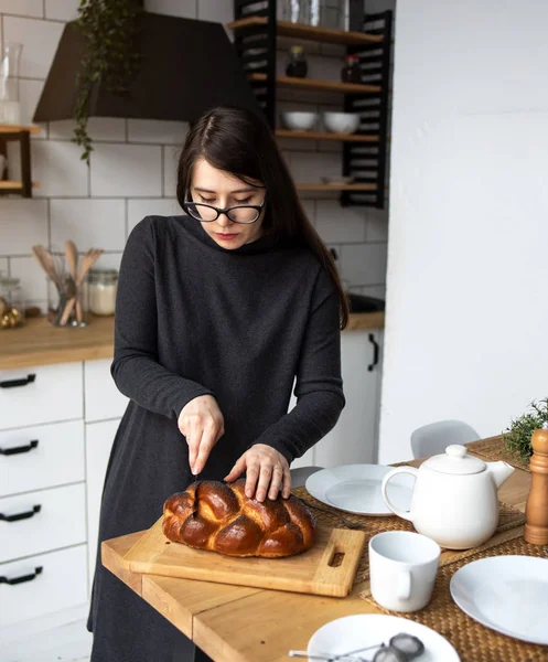 Mutfakta gri elbiseli, siyah saçlı güzel bir kadın. Modern beyaz mutfak.