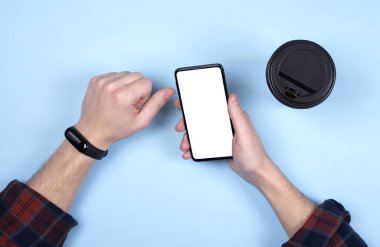 Erkeklerin elindeki akıllı telefon. Bir fincan kahve, elinde akıllı bir saat..