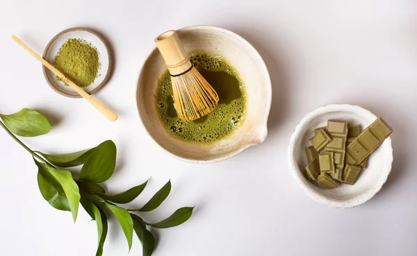 Açık gri arka planda matcha hazırlığı. Vejetaryen çikolata.