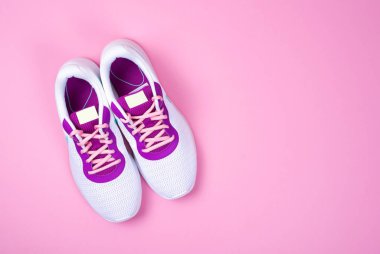 Pembe arka planda beyaz kadın ayakkabıları..