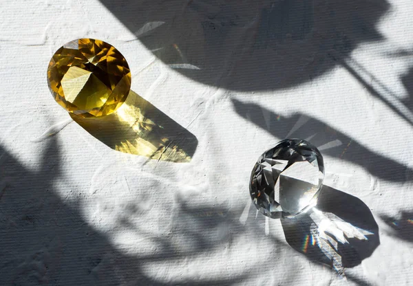 Two transparent crystals on a white background. Bright sunlight. The summer mood. — Stock Photo, Image