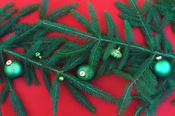 Branches of a living Christmas tree with New Year's toys on a red background. — Stock Photo, Image