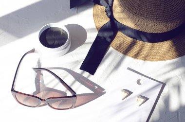 Bir palmiye ağacının gölgesinde beyaz bir arka planda kadın aksesuarları fotoğrafı.