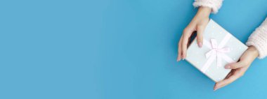 Turkuaz arka planda elinde bir hediye olan web pankartı.