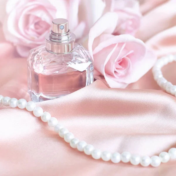 Flacon de parfum féminin, rose, perles sur soie rose . — Photo