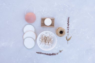 Gri arka planda çevre dostu ev ve banyo aksesuarları.