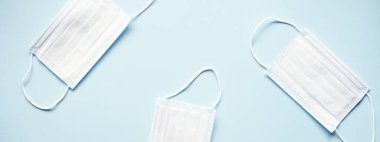 Açık mavi arka planda tıbbi maskeli site afişi. Asgari tıbbi konsept.