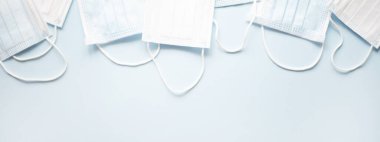 Açık mavi arka planda tıbbi maskeli site için pankart. 