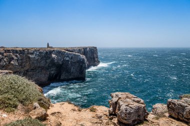 Portekiz 'in Algarve kentindeki Atlantik kıyısındaki uçurumun tepesindeki tenha deniz fenerinde güneşli bir hava var. Malzemesiz Kraliyet fotoğrafı..