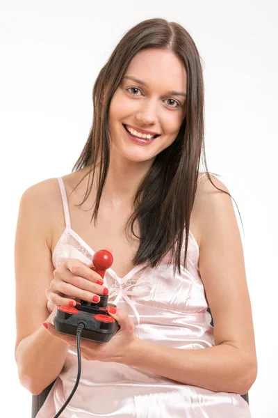 Atractiva Joven Morena Vistiendo Camisón Rosa Divirtiéndose Sosteniendo Joystick Foto —  Fotos de Stock