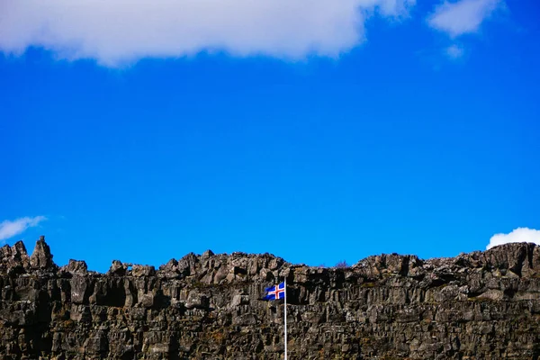 Bandeira Islandesa na frente das rochas — Fotografia de Stock