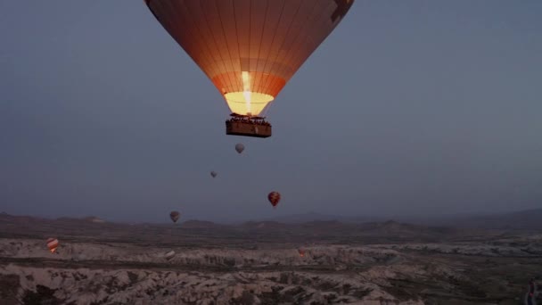 Cappadocia, Törökország. Hajnalban egy léggömb repül az égen. — Stock videók