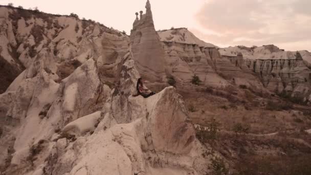Каппадокия, долина любви, девушка-хиппи играет на гитаре на холме — стоковое видео