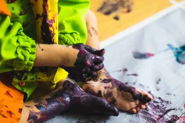 Pequeño niño manos y pies cubiertos de múltiples colores — Foto de Stock