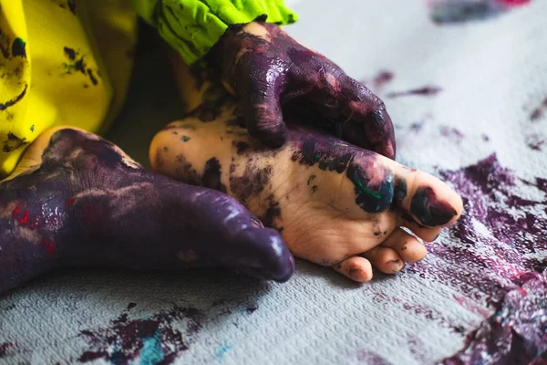 Pequeño niño manos y pies cubiertos de múltiples colores — Foto de Stock