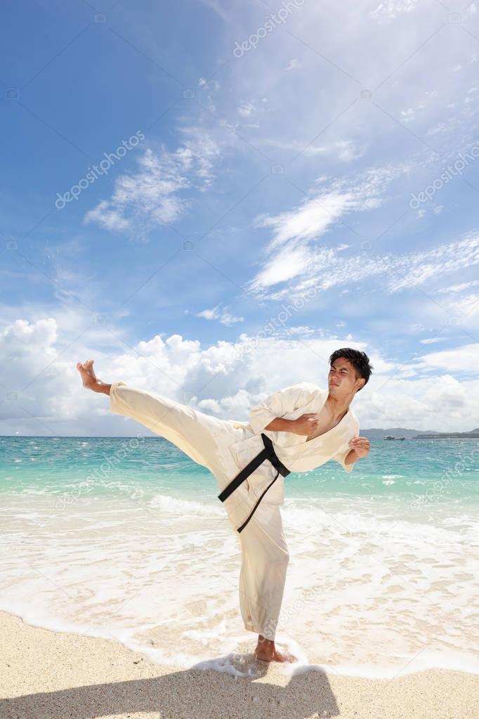 One Asian man playing with taekwondo outdoor.