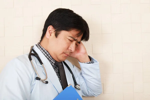 Tired Asian doctor — Stock Photo, Image