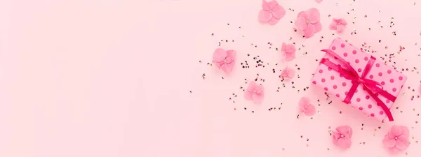 Banner met Gift box glitter confetti en bloemen op roze vakantie kopieerruimte. — Stockfoto