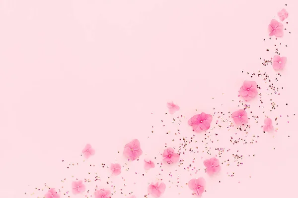 Holiday frame of pink flowers and gold confetti spread on copy space. — Stock Photo, Image