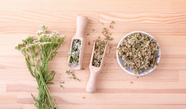 civanperçemi çayı / Top iki kaşık taze ve kurutulmuş çiçeklerin ve civanperçemi ahşap arka plan ile yaprakların görünümü 