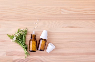 Civanperçemi Homeopathic Tıp / üstten çiçeklenme civanperçemi ahşap bir arka plan ile homeopatik ilaç görünümünü