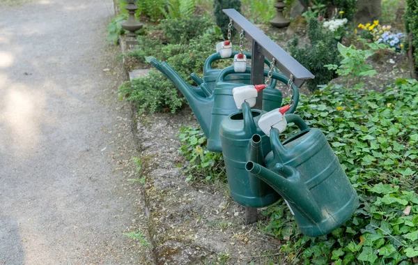 Flower Bed Four Green Watering Cans — Stock Photo, Image