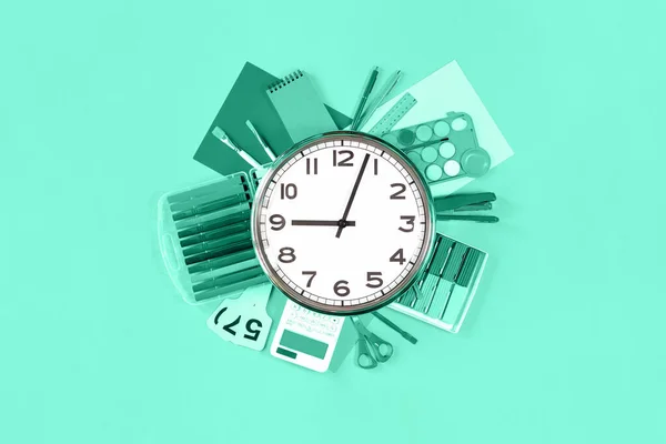 Clock over office and school stationery monochrome green