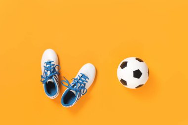 Futbol topu ve kramponlar modaya uygun arka plana karşı