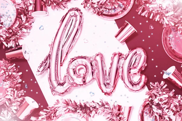 Pink metallic love word foil balloon on party table