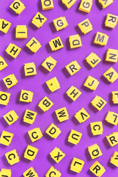 Slovo Dyslexia žluté na růžové fialové s roztroušenými kostkami písmen — Stock fotografie