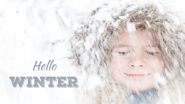 Rosto de criança com os olhos fechados sorrindo com neve borrada caindo — Fotografia de Stock